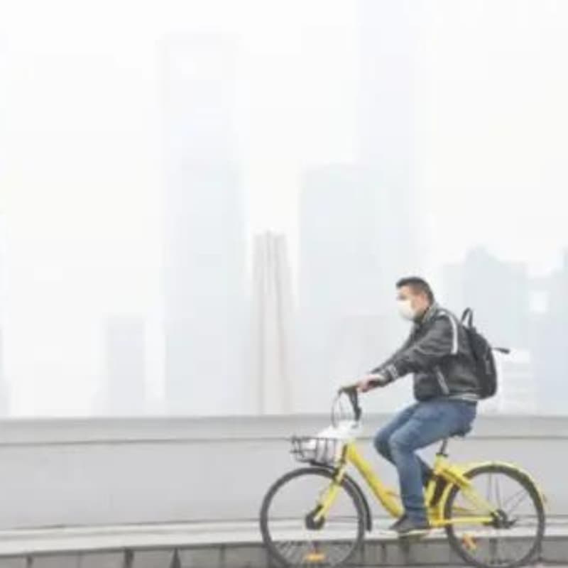 Cycliste a shangai recouverte de particules fines de pollution